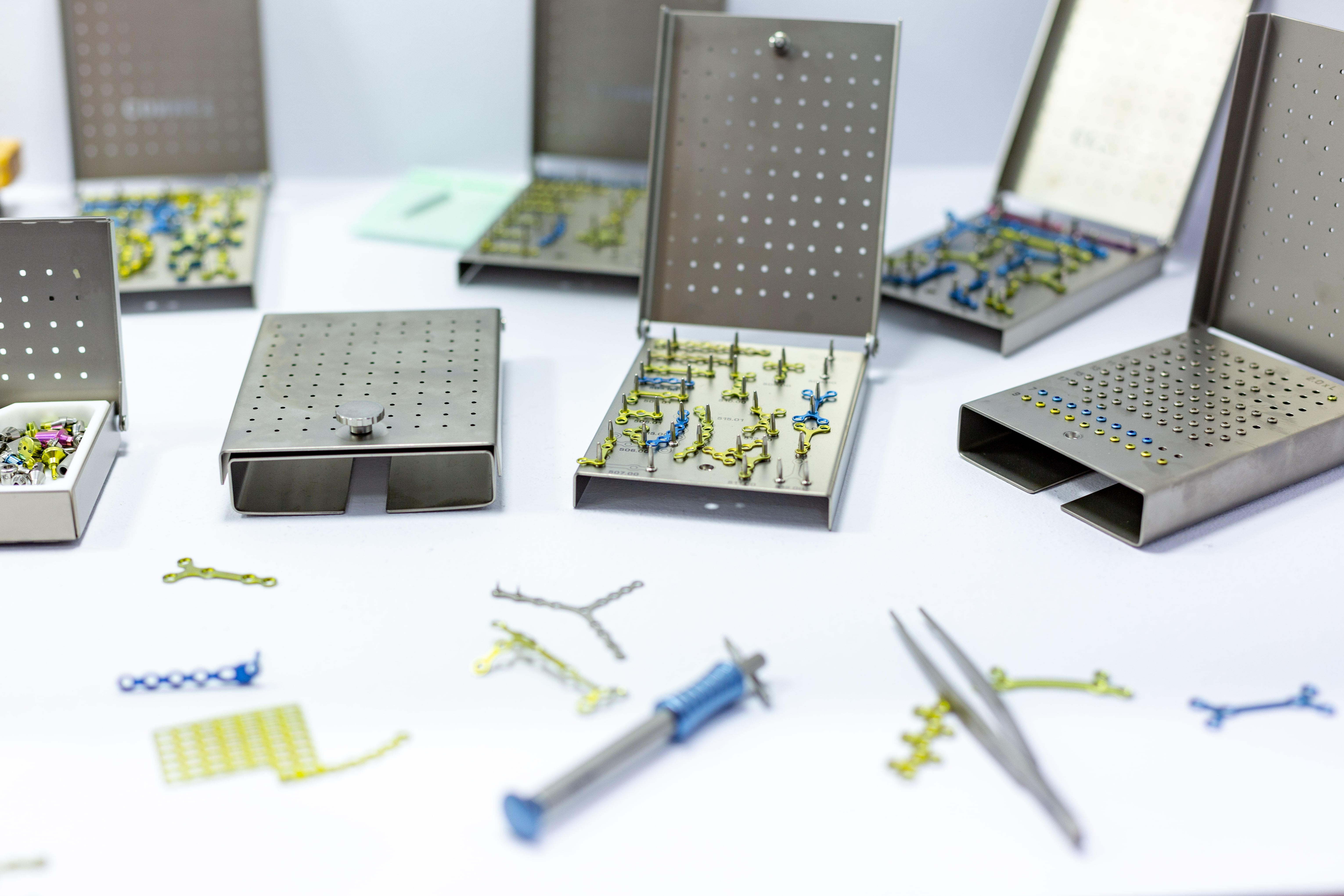 Orthopädische Implantate, Schrauben und Fixationsplatten in Edelstahlboxen – Symbol für Materialprüfung, Biokompatibilität und biologische Sicherheit von Medizinprodukten nach EU-MDR-Richtlinien.