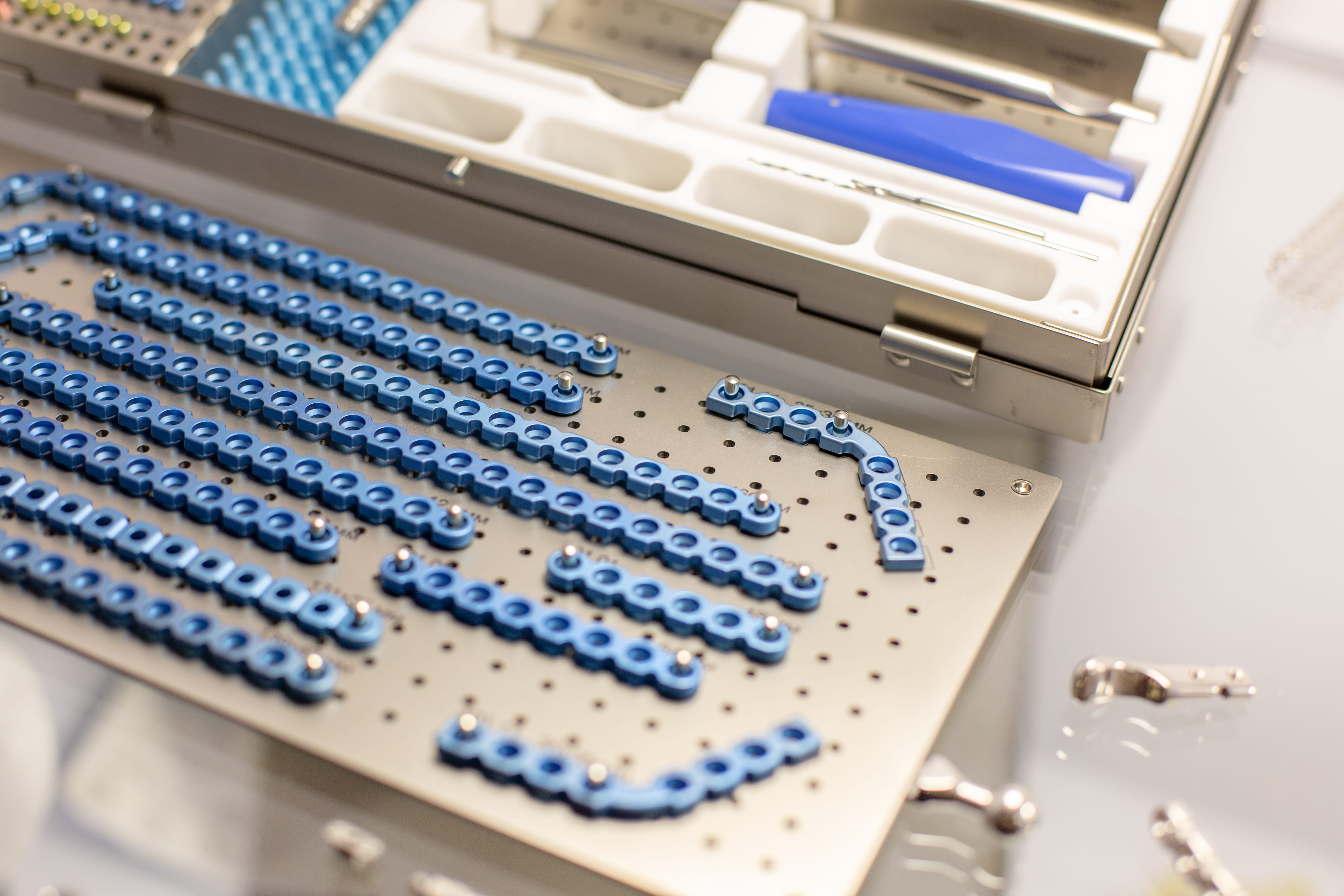 Chirurgisches Implantatsystem mit Titan-Fixationsplatten und Prüfwerkzeugen, stellvertretend für regulatorische Tests und toxikologische Bewertung biokompatibler Materialien in der Medizintechnik.
